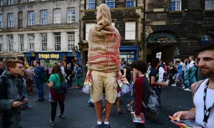 A street entertainer performs on Edinburgh's Royal Mile during the festival fringe in August 2013